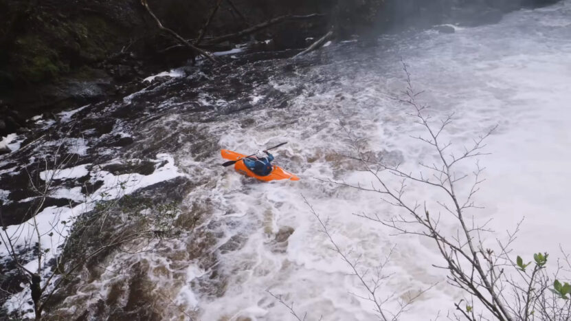 A guy kayaking on a rough river