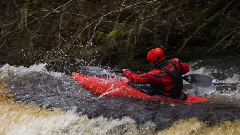 A guy with a kayak at a dangerous waterfall